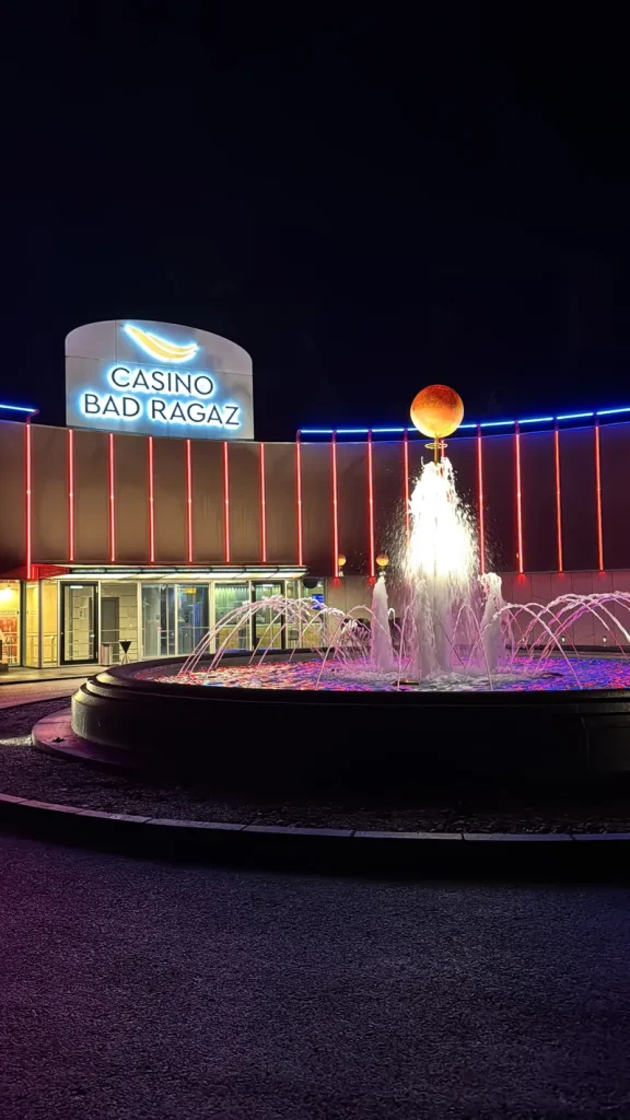 Casino Bad Ragaz bei Nacht mit beleuchtetem Brunnen